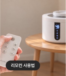 리모컨을 들고 있는 손과 협탁 위 가습기
